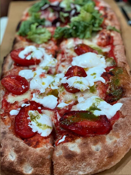 Pizza alla pala with cherry tomatoes, mozzarella and basil